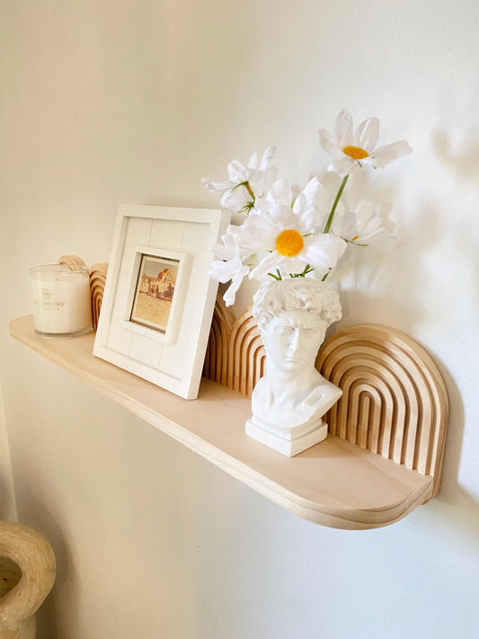 Handmade wooden floating shelf with an arched layered backplate, crafted from light natural wood. Mid-century modern and art deco-inspired design, perfect for displaying decor, vases, framed art, and candles. Wall-mounted and ideal for minimalist, boho, or contemporary interiors.